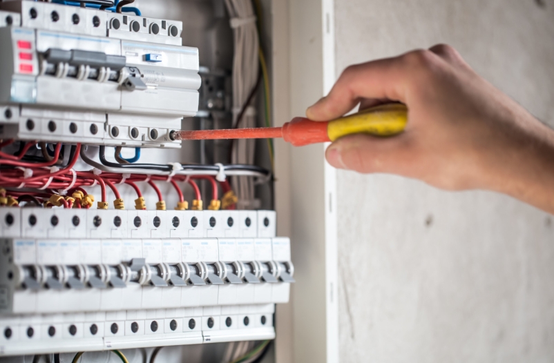 man electrical technician working switchboard with fuses installation connection electrical equipment