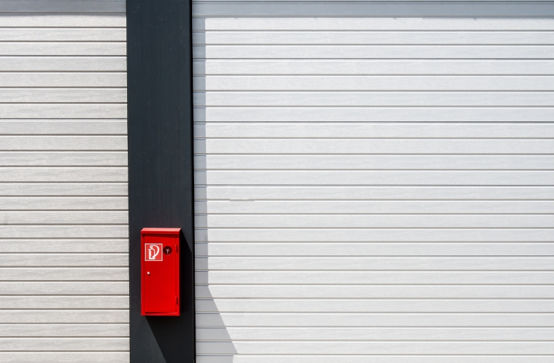 red fire box hung black white surface with lines scaled